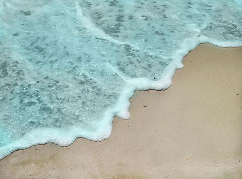 Photo of the blue ocean coming up on the beach