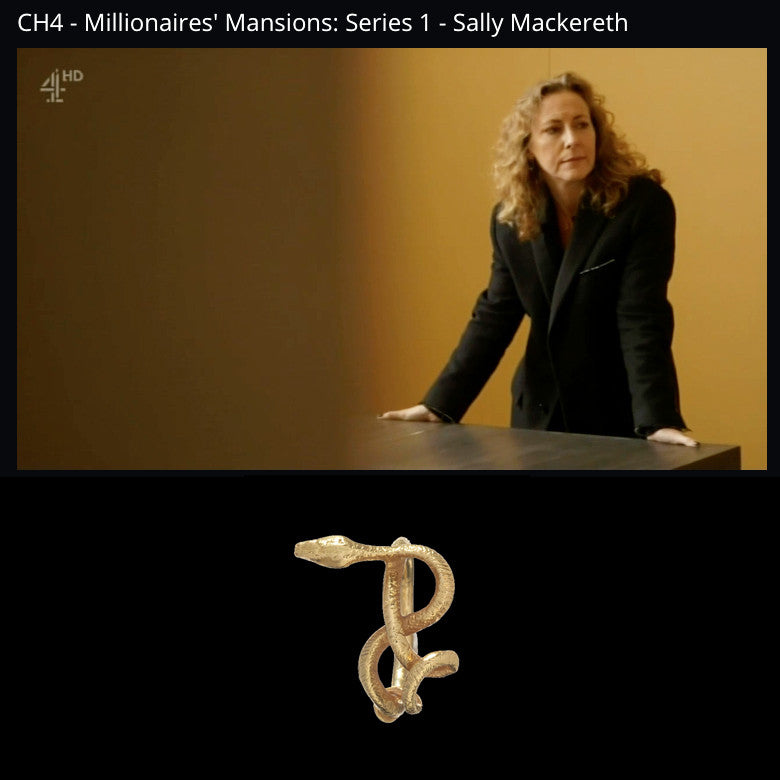 Architect Sally Mackereth stands above a bespoke table she made while wearing our 18k gold wadjet twisted snake ring