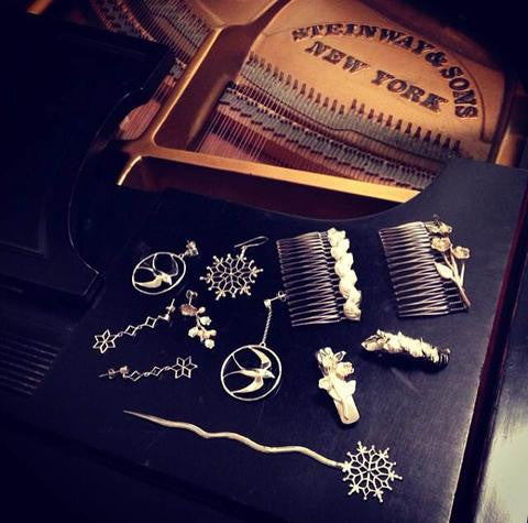 An array of jewelry pieces sit on a piano