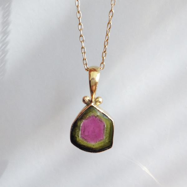 photo of the rainbow tourmaline charm on a necklace in 18k rose gold